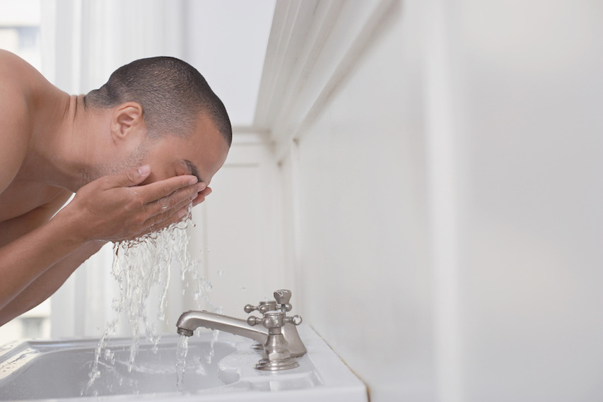 Man cleansing skin before shaving face