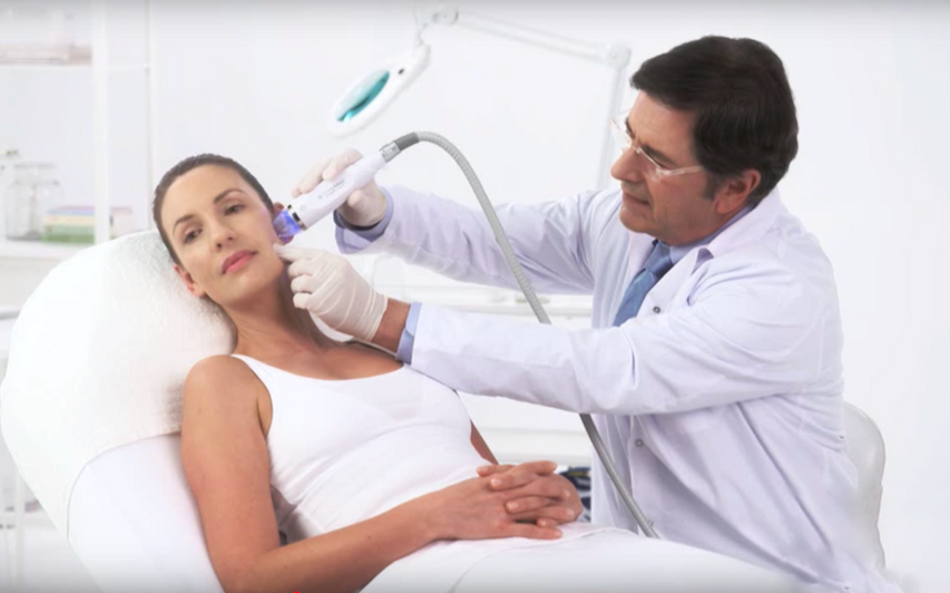 Dermatologist conducting microneedle radio frequency on women with acne scars