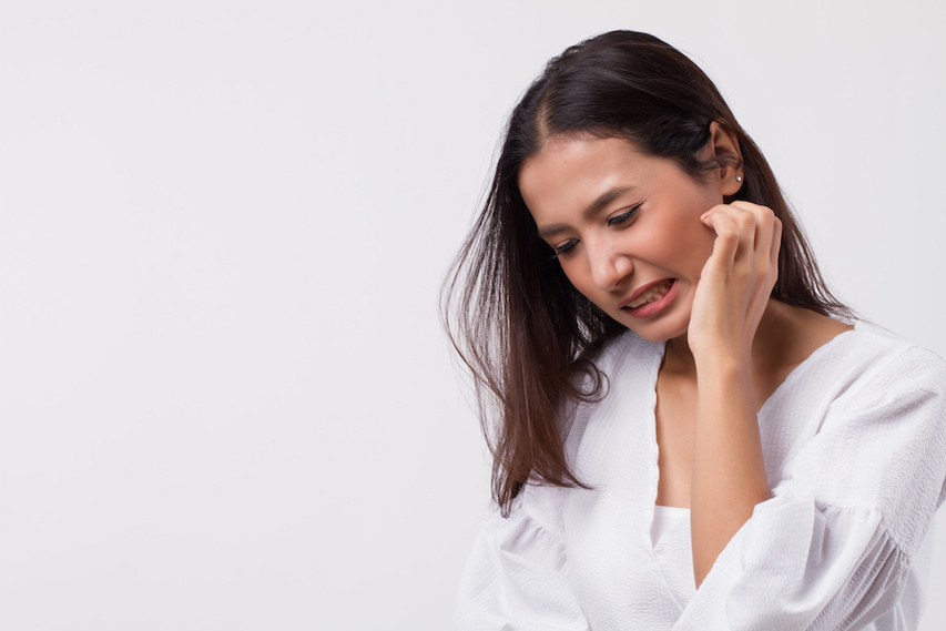 Woman itching sensitive skin that gets easily irritated