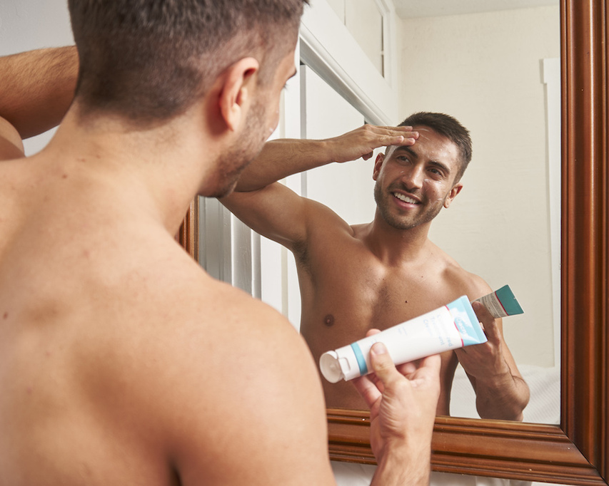 Man applying MDacne Customized Acne Treatment Cream to acne-prone areas of face