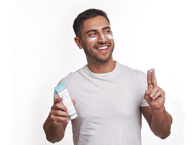 Man applying MDacne oil-free sunscreen as a moisturizer